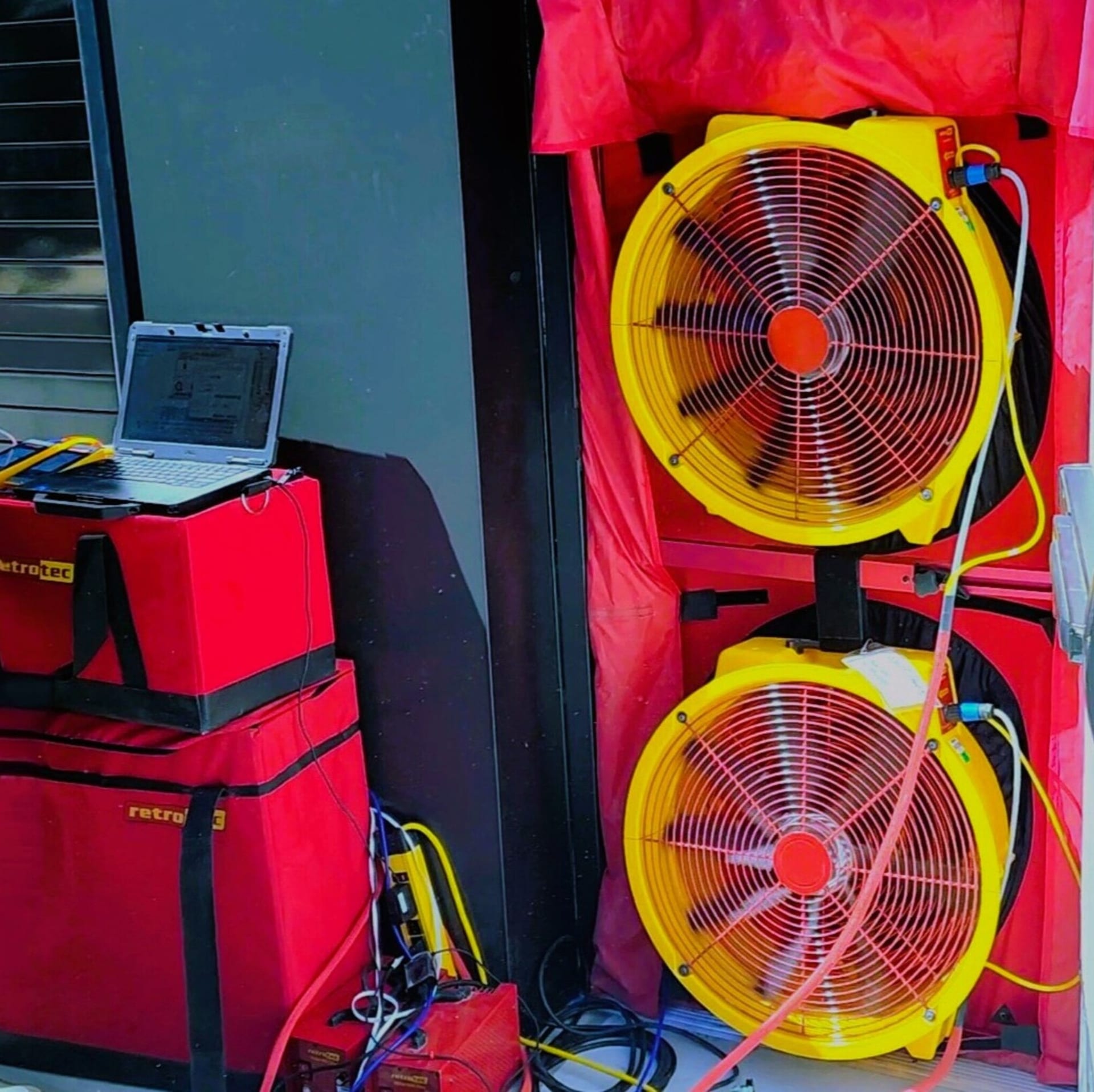 Technician performing a blower door test on a building